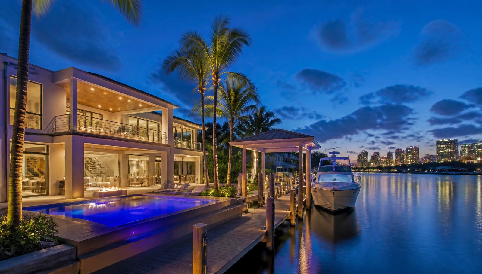 Fort Lauderdale waterfront home on a no-fixed-bridge canal with a private dock and yacht at blue hour